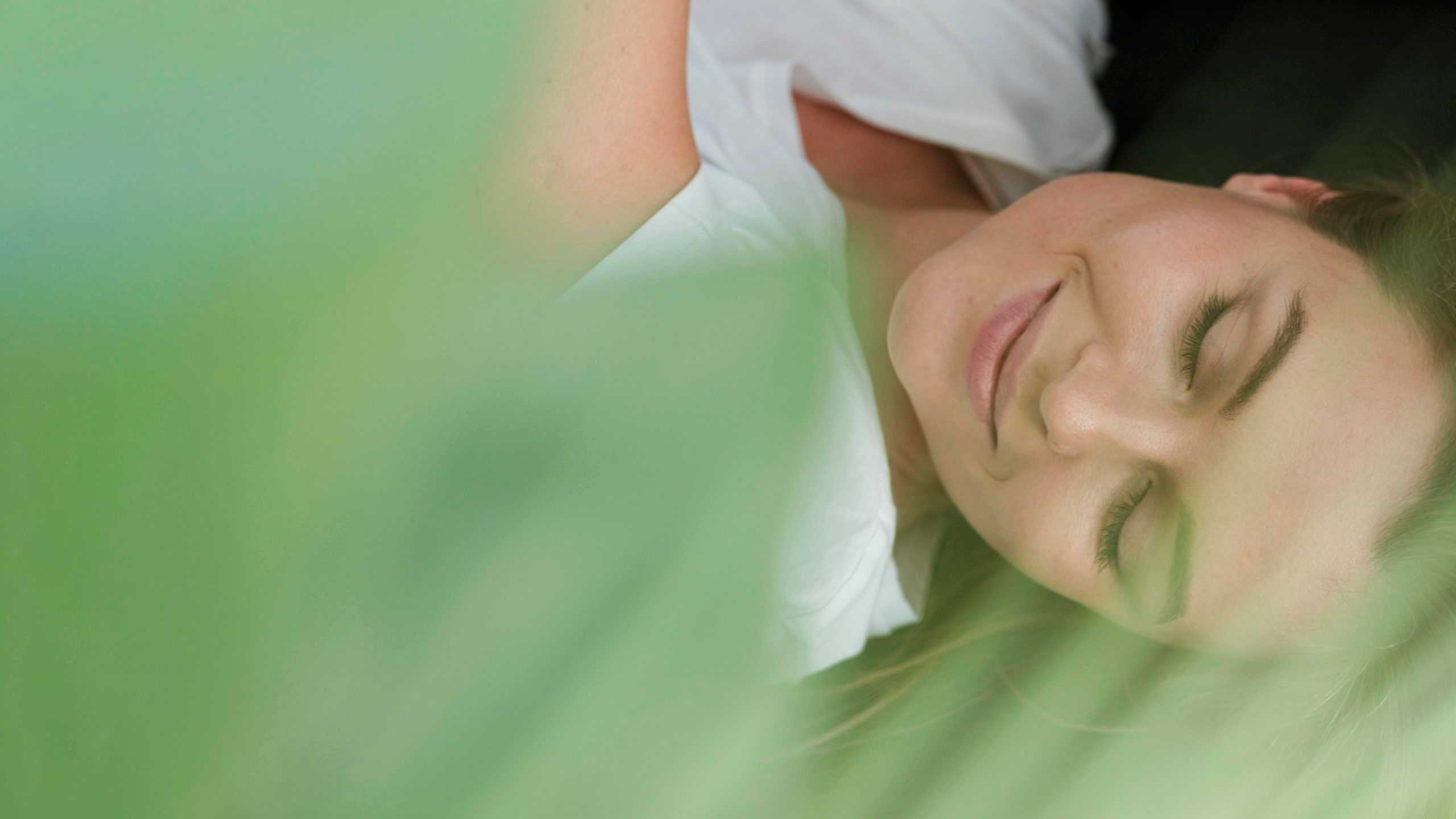 close-up-woman-with-closed-eyes-and-blurred-plant-scaled