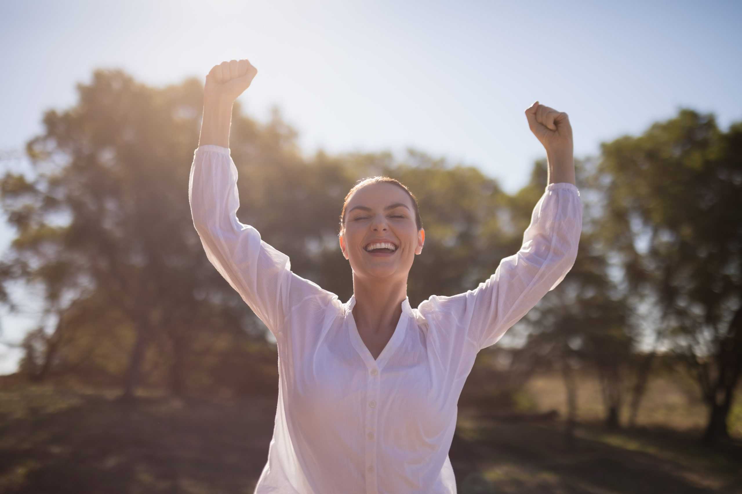 woman-standing-with-arms-up-during-safari-vacation-scaled