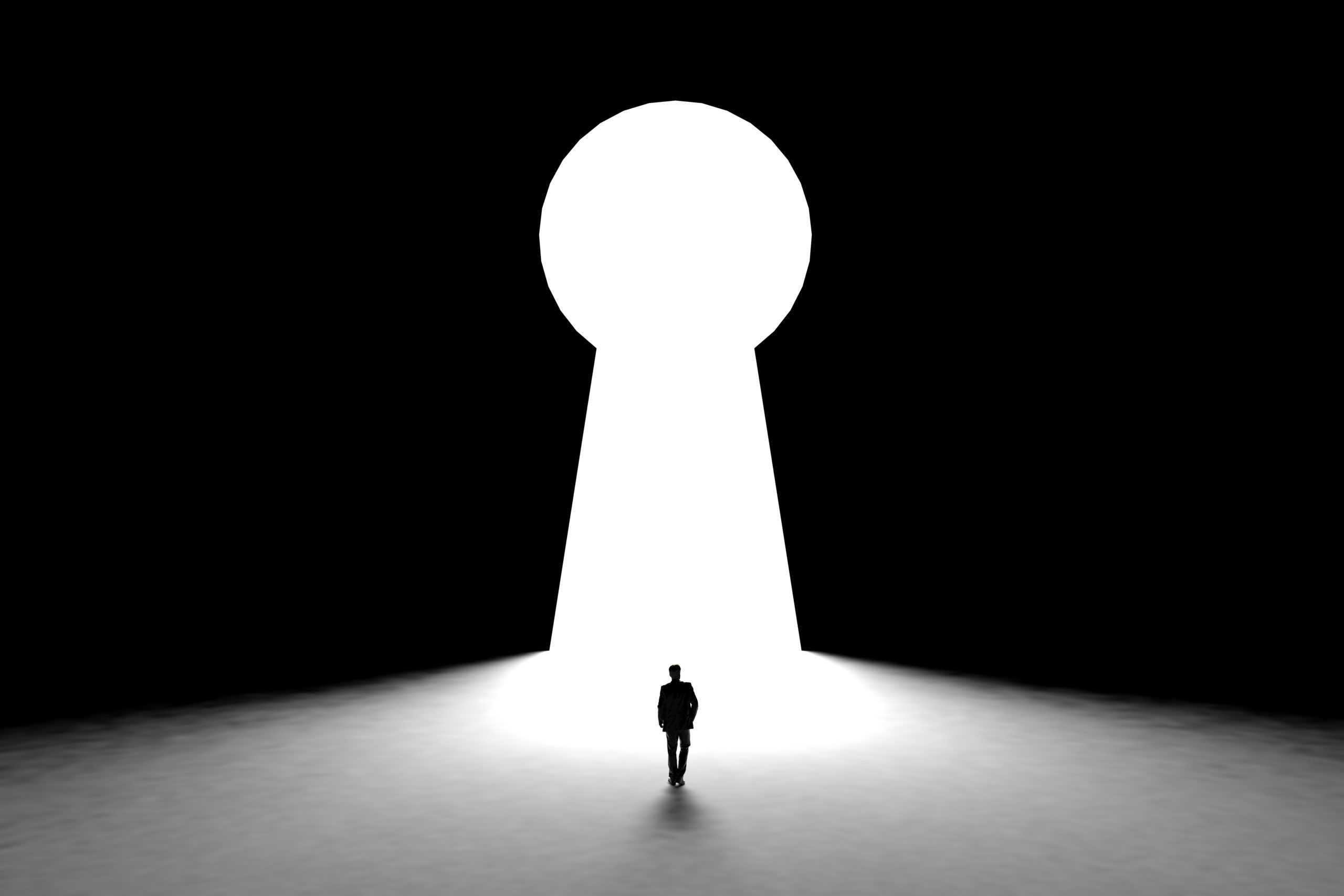 miniature-businessman-standing-in-front-of-wall-with-key-hole-door-background-scaled